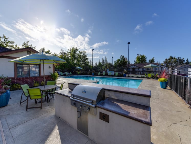 BBQ and Seating Area with Grills, Table, Blue/Yellow Patio Umbrella, Lime Green Chairs and View of Pool